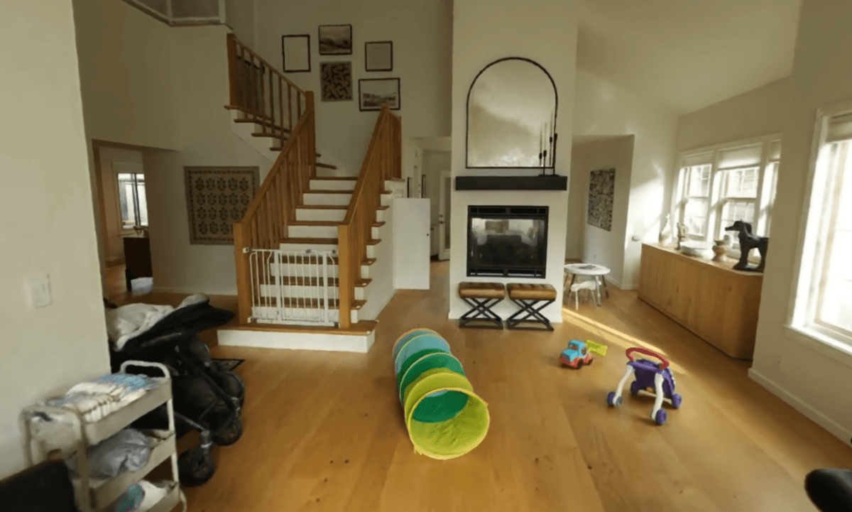 A 3D scene from a house, you see children's toys flying around and a staircase.